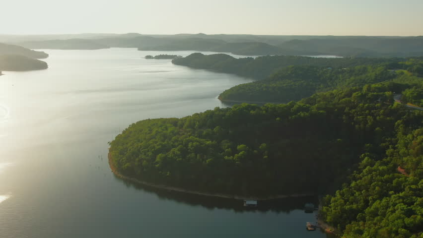Aerial tilt down over lush vegetation of Beaver Lake natural shoreline, Arkansas, USA
