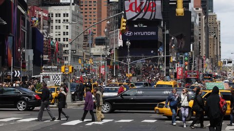 NEW YORK CITY, USA - APRIL 18, 2013 Busy Tourists passing visit Famous Popular Times Square, Crowded People Walking in NYC, Pedestrians crossing on Crosswalk Sidewalk, Black Limousine Yellow Cab Taxi
