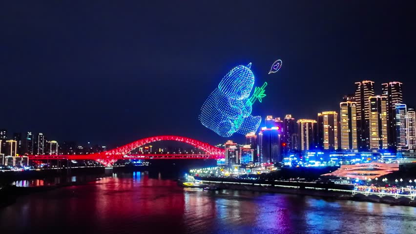 ChaoTianMen, Chongqing, China - A Vibrant Drone Light Show Forms a Colorful Figure Above the Illuminated Red Bridge and Riverfront Skyline, Creating a Striking Nighttime City Scene - Handheld Shot