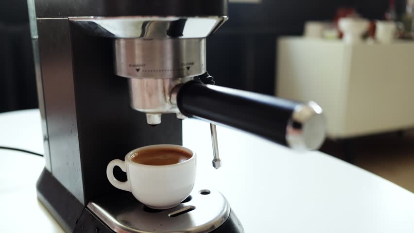 Close-up view of an espresso machine dispensing a fresh, hot coffee into a delicate ceramic cup, capturing the essence of morning ritual