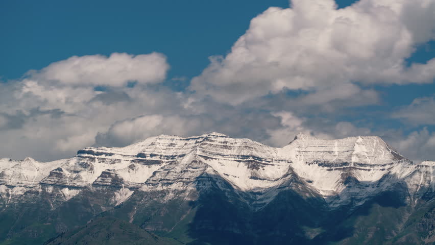 Timelapse of clouds moving over Timpanogos Mountain with snow covering the peaks.