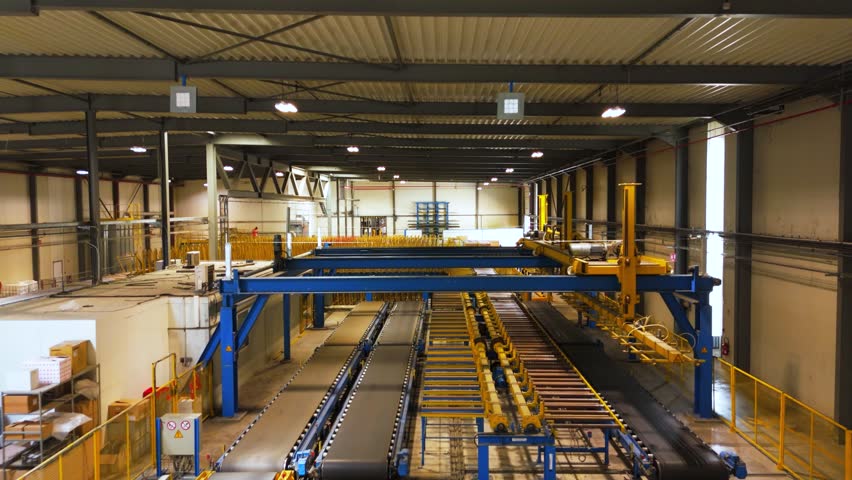 Production line inside a modern manufacturing facility, featuring automated assembly systems, conveyor belts, and heavy industrial machinery for large-scale fabrication.