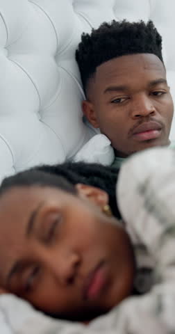 Angry, man and couple in bed with conflict, argument and tension from disagreement. Upset, black people and ignoring partner at house for silent treatment, emotional distance and sleepless with drama