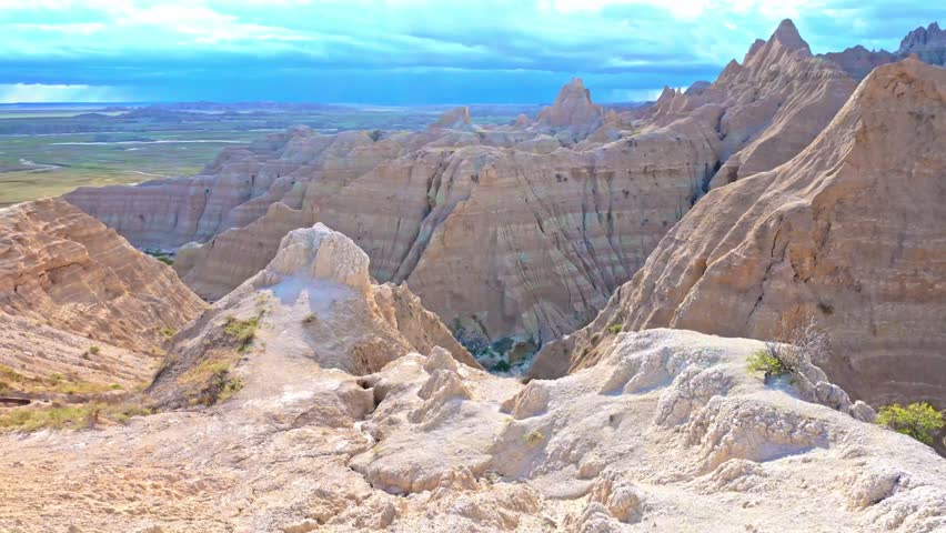 Hiking trail leading through eroded rock formations and prairie grassland at Badlands National Park, South Dakota