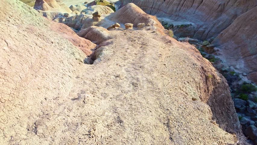 Hiking trail leading through eroded rock formations and prairie grassland at Badlands National Park, South Dakota