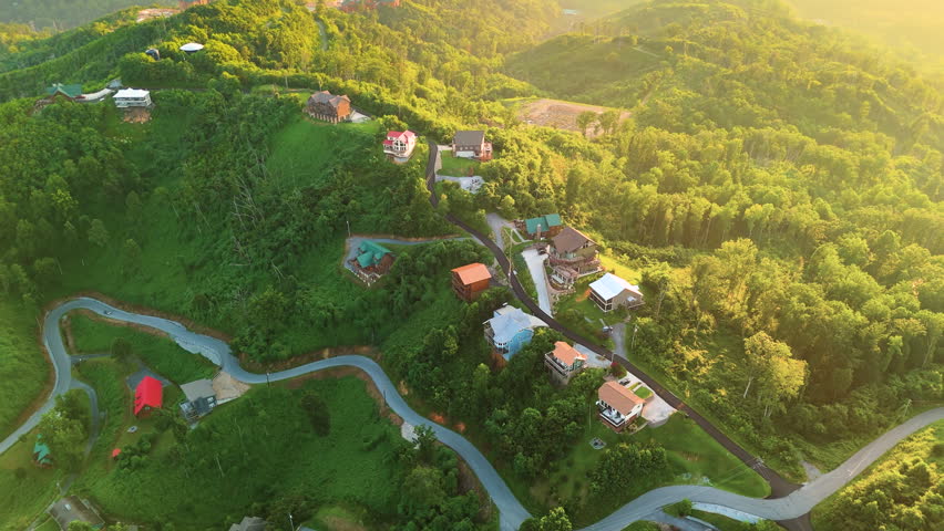 Aerial view of luxury mountain homes surrounded by lush forest and rolling hills in the Smoky Mountains in colorful summer
