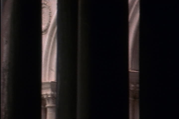 Camera pans from Procuratie facade to darkness behind column in Venice, Italy.