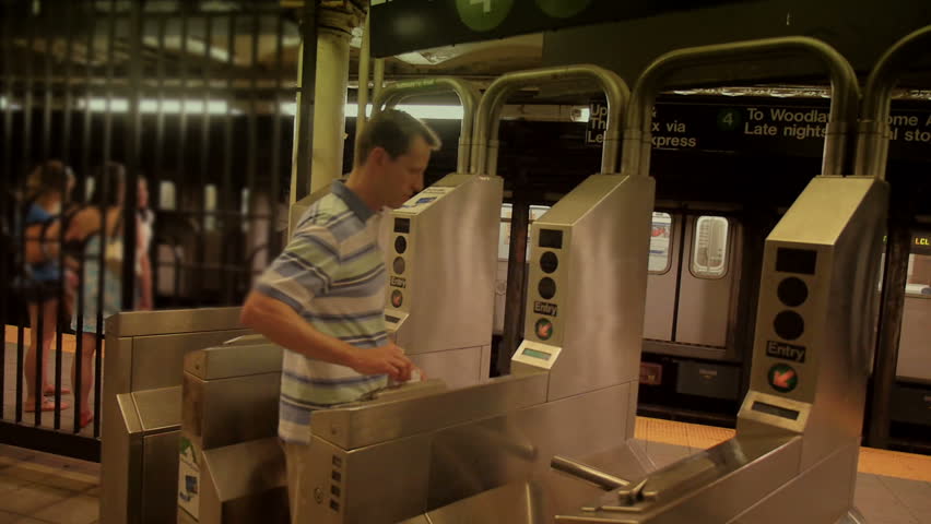 A man passes through the turnstiles of a subway station in New York City.