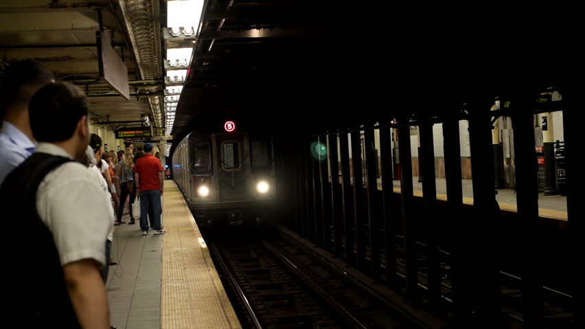 NEW YORK CITY, Circa June, 2013 - Commuters await an approaching subway train.
