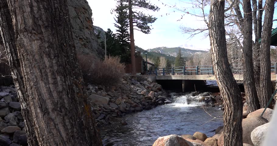 River flowing under a pedestrian bridge in Estes Park, Colorado