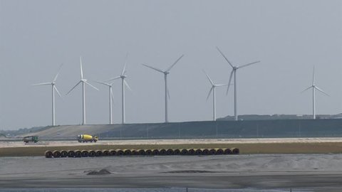 MAASVLAKTE 2, PORT OF ROTTERDAM - 28 MAY 2013: Construction Works Land reclamation for industrial area + wind turbines on sea dike in background