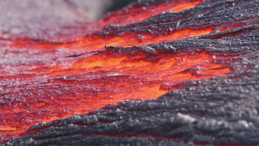Extreme close-up of glowing lava flowing beneath a thin crust at Kīlauea Volcano, Hawaii. Molten magma creates vivid textures and patterns in an active lava flow.