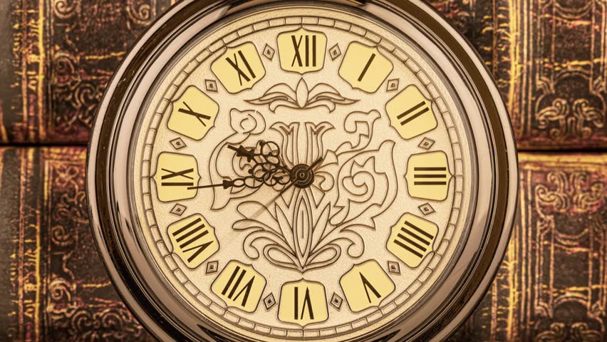 Ornate silver timepiece spinning slowly over old leather books.