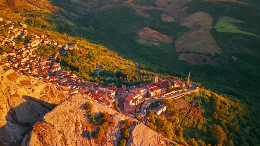 Aerial view of Castelmezzano village at sunset in Potenza, Basilicata, Italy, picturesque settlement nestled among the Dolomiti Lucane mountains with historic stone houses and dramatic rocky landscape