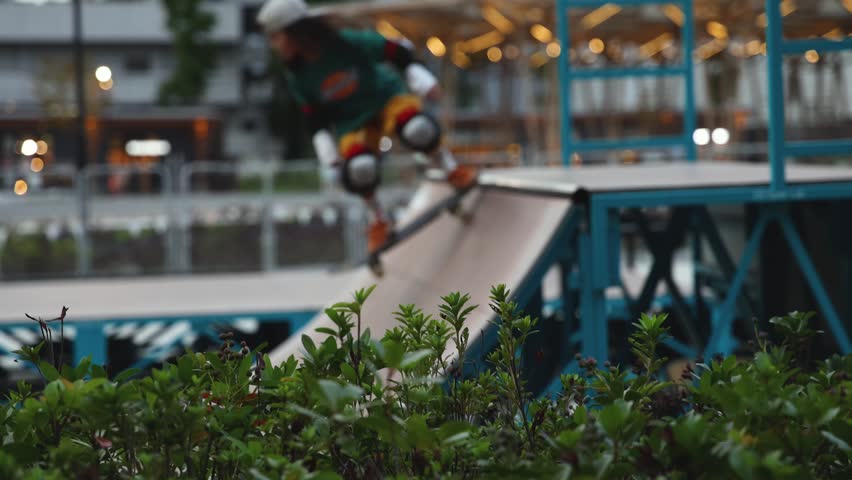 Skate park with kids on a kick scooter doing tricks and stunts, boys and girls in a skate park riding bmx bike and skate, playing and enjoying summer on new ramp, teenagers skateboarders and riders 