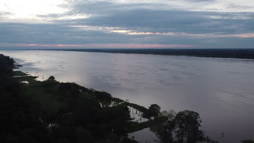 Aerial view showing the amazon river and the rainforest at sunset near iquitos, peru. Santa clara de ojeal