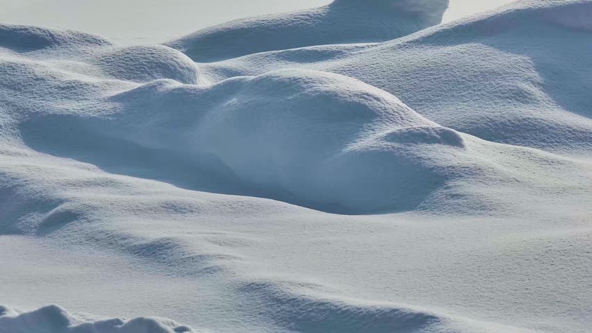 The scene is minimalist and abstract, resembling a frozen desert of white dunes or a tranquil snow-covered terrain untouched by human activity. The image conveys a sense of calm, purity, and the quiet beauty of winter nature.