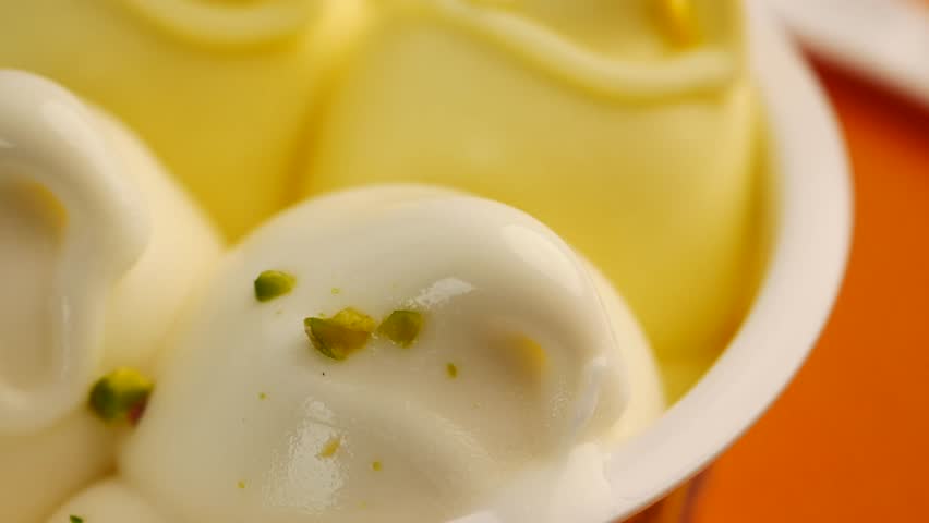 Creamy dessert topped with nuts in vibrant bowl