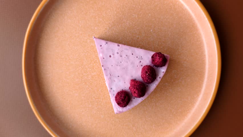 Raspberry or strawberry cheesecake, a slice of sweet red cake with berries. Raspberry cheesecake