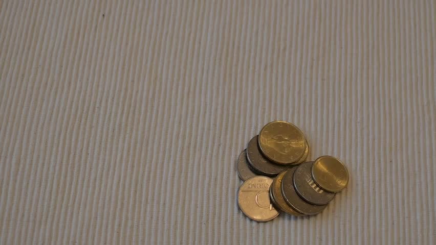 Close-up of a hand taking Hungarian forint coins, representing financial pressure, savings and scarcity.