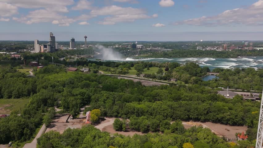 Drone view of the Niagara Falls skyline with rushing Niagara River and mist rising from the waterfalls