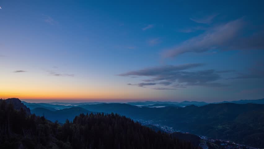 Cloudy weather over hills covered with spruce forests in Rhodope Mountains and fog between mountain ranges