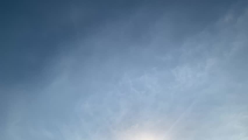 4K bright sun shining through dramatic clouds above Jakarta, Indonesia. Upward view with soft lens flare, vivid blue sky and natural light, ideal for weather, energy, inspiration and nature themes.
