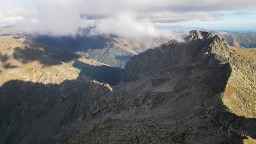 4K aerial reveals the rugged Negoiu summit rising above glacial valleys and alpine ridges in the Southern Carpathians.