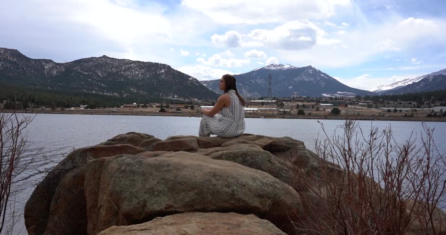 Woman sitting on rock and looking at alpine views in Estes Park, Colorado