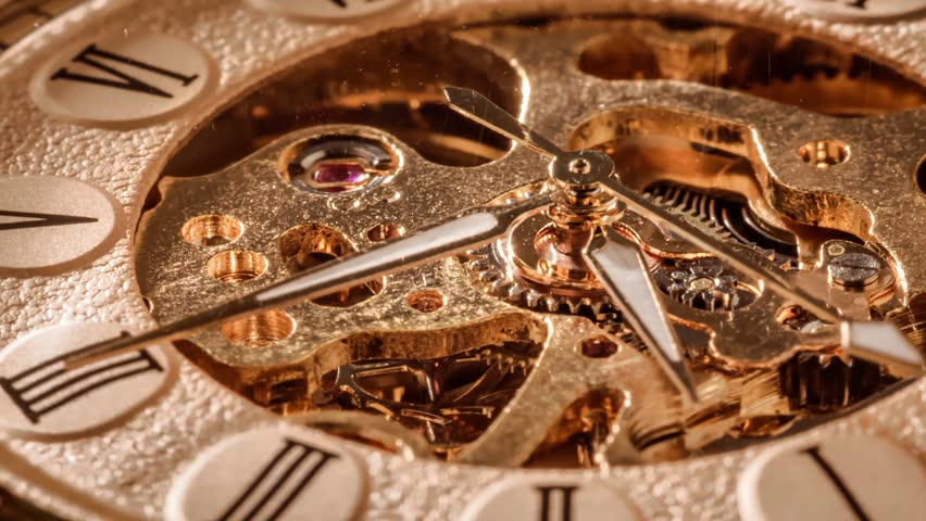 Close up of clockwork mechanism showing gears and hands.