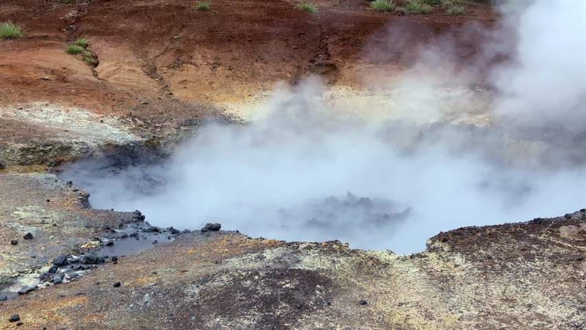 Boiling mud pot and hot spring emitting thick steam in the Seltun geothermal area in Krysuvik. Volcanic landscape on Reykjanes Peninsula