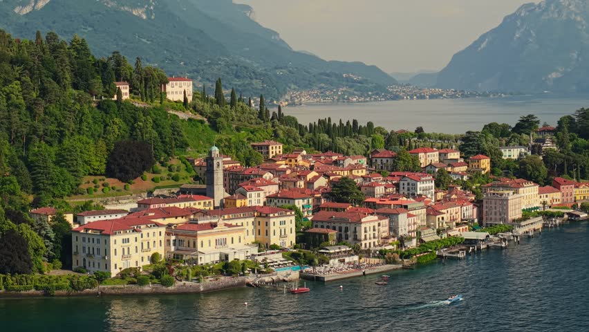 Aerial view of famous Bellagio town on Lake Como shore, luxury villas and historic houses in Italy. Bellagio village with red tiled roofs, summer travel destination by Lake Como in Lombardy