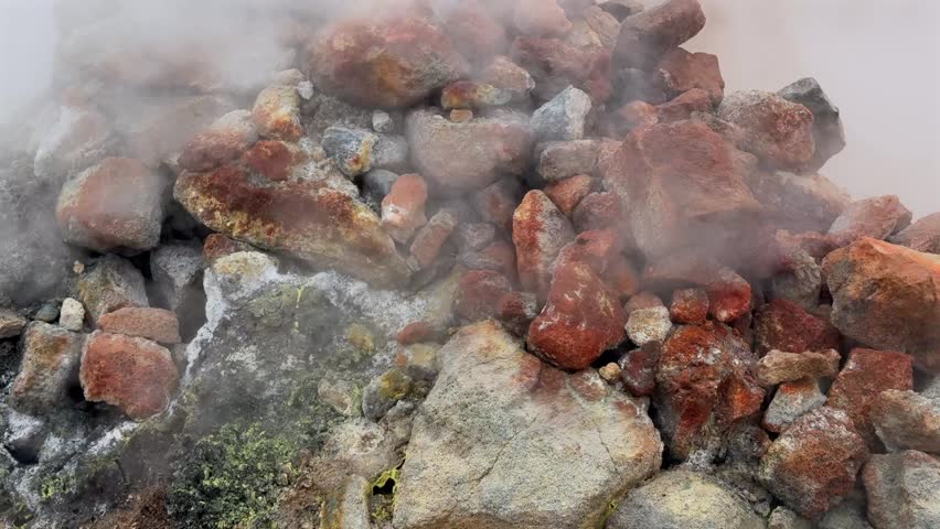 Volcanic fumarole emitting hot steam and sulfurous gases in the Hverir geothermal area of Iceland. Close up on colorful mineral deposits