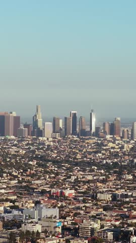 Cinematic panorama of Downtown Los Angeles skyline showcasing high rise buildings and sprawling urban development under hazy california sky with iconic skyscrapers on horizon