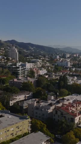 Aerial footage of luxury hotels in West Hollywood urban borough. Hills and clear blue sky. Los Angeles, California, USA
