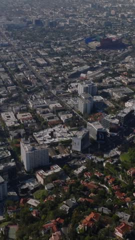 High angle view of complex of multistorey hotel buildings in urban borough. Tilt up reveal of cityscape. Los Angeles, California, USA