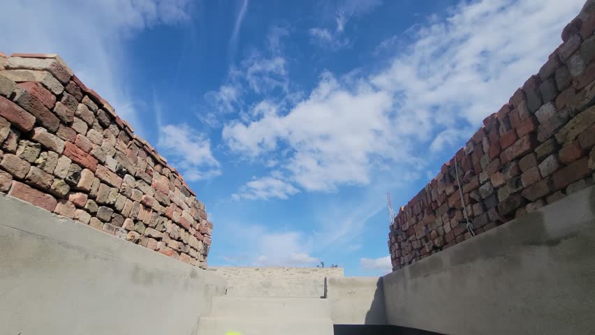Low angle perspective of brick walls under a clear blue sky