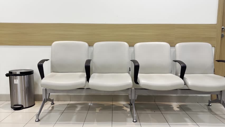 Rows of empty chairs inside a hospital waiting room, representing healthcare facilities, patient services, and medical environments.