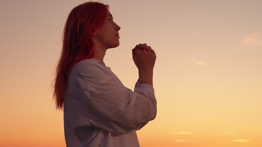 Girl confesses. Christian woman praying sunset, close-up. Faith God. Woman prays family children against backdrop sky sun. Relaxation meditation nature. Apologizing. Hope. People religion. Silhouette