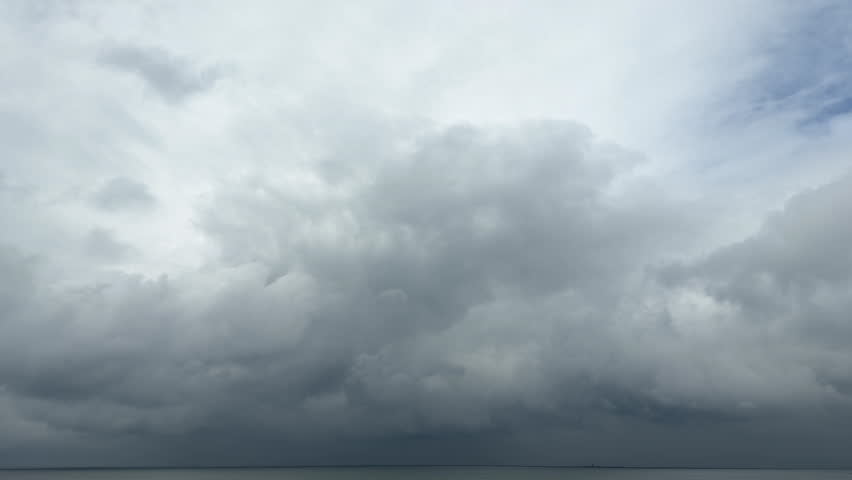 A seascape with a cloudy sky, vast clouds, and a calm horizon