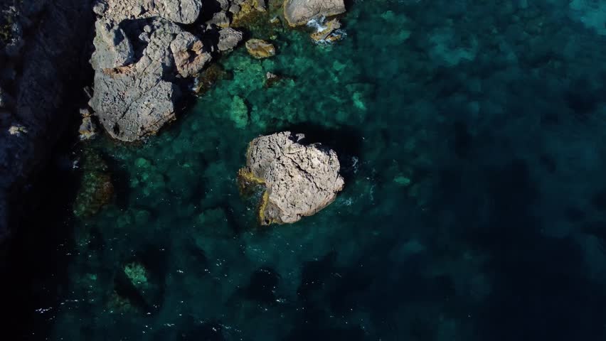 Aerial top down view of the stunning rocky coastline of hvar island, croatia. Crystal clear turquoise water revealing the seabed