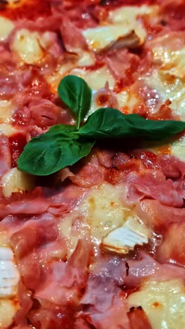 A delicious gourmet pizza topped with melted cheese, thin slices of prosciutto, and fresh basil leaves. Ideal for food blogs or culinary marketing.