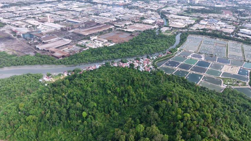 Aerial drone view of Kampung Sungai Semilang Juru river, mangrove and nearby industrial ponds.