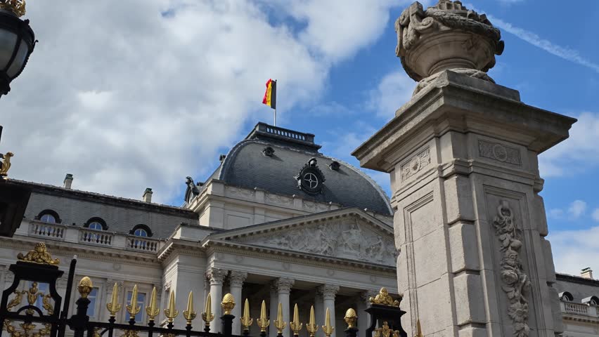 Brussels Royal Palace. 4K video shot of the grand Royal Palace of Brussels, featuring neoclassical white architecture, manicured green garden hedges, and the Belgian flag waving. Belgium landmark