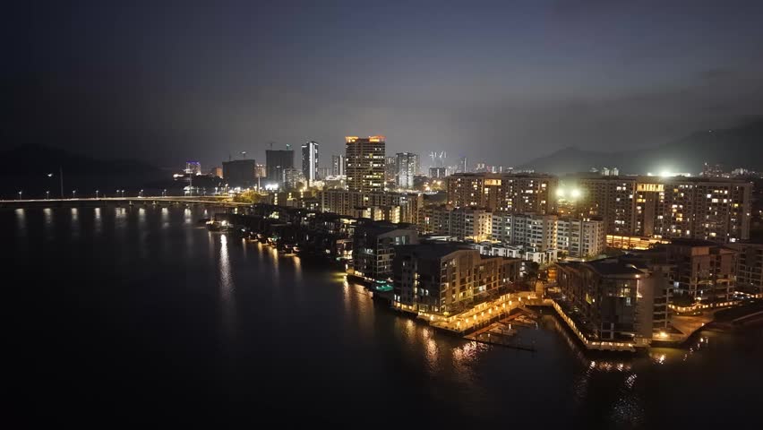 Drone footage showing The Light City waterfront and skyline in Penang at night.