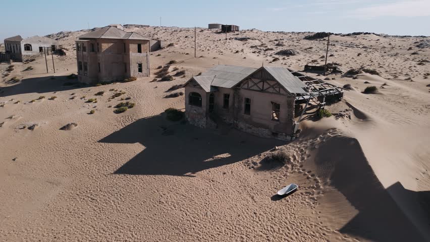 Abandoned ghost town of kolmanskop in the namib desert reclaimed by nature and sand dunes an aerial view.