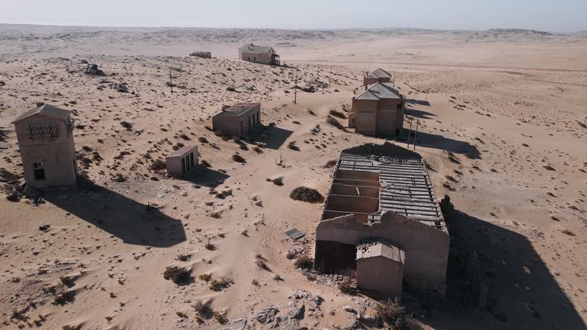 Abandoned ghost town kolmanskop in namib desert, namibia. Aerial view of decaying houses swallowed by sand and desolation.
