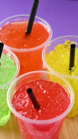 Colorful fruit slushies rotating on purple and black background