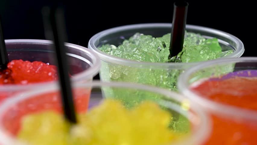 Colorful fruit slushies rotating on purple and black background