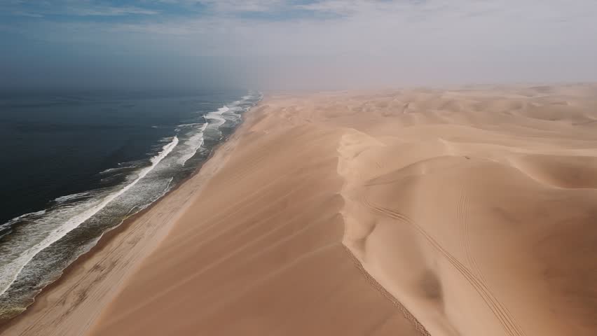 Aerial view of the namib desert meeting the atlantic ocean at sandwich harbour in namibia, an amazing natural landscape.